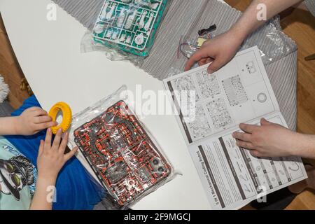 Nahaufnahme der Handhaltung von Kindern und Männern für ein neues Spiel. Kindheit und Elternschaft Konzept. Stockfoto