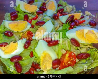 Farbenfroher Salat mit frischem Gemüse, Kalamata-Oliven und gekochten Eiern in einer Schüssel Stockfoto