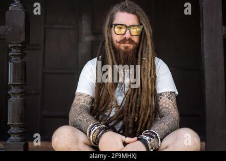 Hipster mit Dreadlocks und Tattoo am Strand In thailan Stockfoto