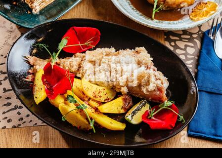 Gegrillter Fisch auf einem Teller mit Gemüse und Sauce Stockfoto