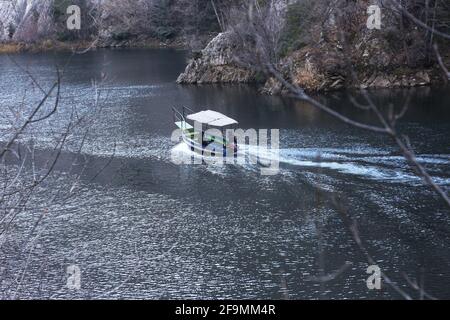 Das Boot fährt am Fluss im Matka Canyon in Skopje, Mazedonien. Matka ist eines der beliebtesten Outdoor-Ziele in Mazedonien. Stockfoto
