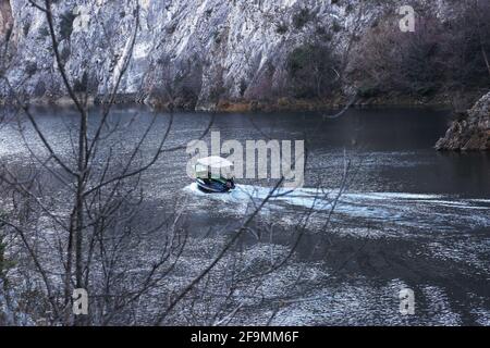 Das Boot fährt am Fluss im Matka Canyon in Skopje, Mazedonien. Matka ist eines der beliebtesten Outdoor-Ziele in Mazedonien. Stockfoto