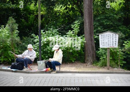 Ein Mann und eine Frau zeichnen und malen die Landschaft rund um den Engakuji-Tempel in der Präfektur Kamakura, Japan Stockfoto