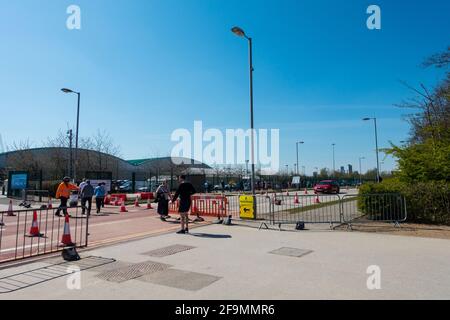 Menschen, die im Etihad Stadium, Manchester, England, Großbritannien, ankommen und sich für ihren Covid 19-Impfstoff anstellen. Stockfoto