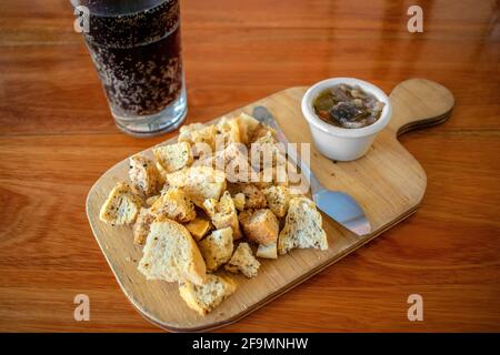 Eingelegte Auberginen mit Toaststücken und einem Glas Soda. Stockfoto