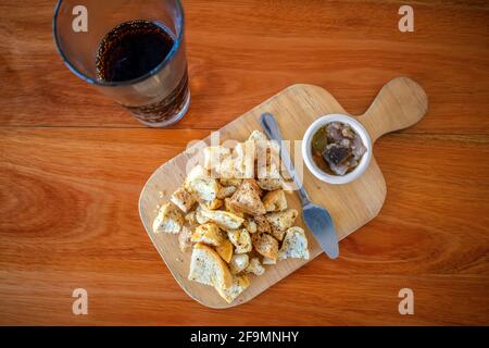 Eingelegte Auberginen mit Toaststücken und einem Glas Soda. Stockfoto