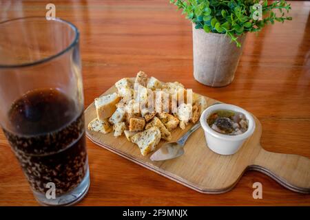 Eingelegte Auberginen mit Toaststücken und einem Glas Soda. Stockfoto