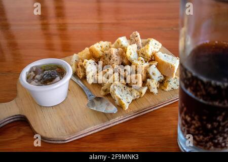 Eingelegte Auberginen mit Toaststücken und einem Glas Soda. Stockfoto