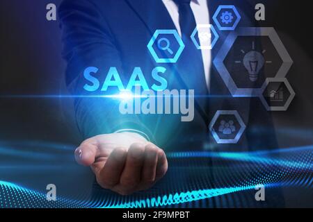 Business, Technologie, Internet und Netzwerkkonzept. Junger Geschäftsmann arbeitet auf einem virtuellen Bildschirm der Zukunft und sieht die Inschrift: SAAS Stockfoto