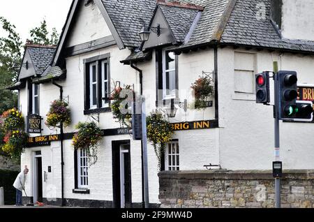 Tranent, East Lothian, Schottland, Vereinigtes Königreich. Vor der Tageseröffnung putzt ein Mann morgens vor einer Kneipe an der Ecke. Stockfoto