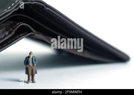 Arme Männer mit leerem Portemonnaie, kein Bargeld. Miniatur winzigen Menschen Spielzeug Fotografie. Isoliert auf weißem Hintergrund. Stockfoto