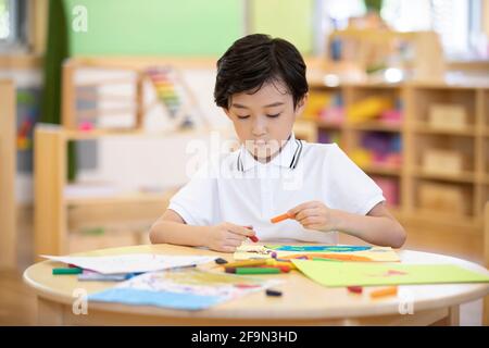 Kleiner Junge Malerei im Klassenzimmer Stockfoto