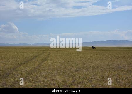 Reiten in der Steppe in der Nähe der Three Camel Lodge in der Wüste Gobi, Mongolei. Stockfoto