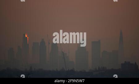 London, Großbritannien. 20. April 2021. Der dünn tief liegende Nebel in den Vororten verdeckt die Wolkenkratzer der Skyline von London vor einem weiteren Sonnentag in der Hauptstadt. Die aufgehende Sonne trifft die obersten Stockwerke des 22-stöckigen Bürogebäudes Bishopsgate in der City of London, 62 Meter hoch. Quelle: Malcolm Park/Alamy Live News. Stockfoto