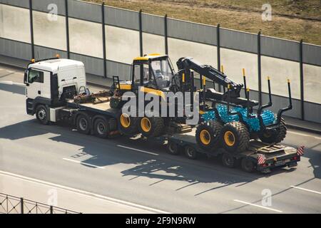 Transport von Ausrüstung für die Verarbeitung von Wald von Baumstämmen Forwarder Maschinen Radernter, Holzindustrie auf der Ladeplattform eines Truc Stockfoto