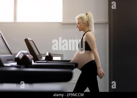 Schwanger Frau Training Laufband-Maschine im Fitnessstudio Cardio-Übungen auf Laufsimulator Laufen Walking gesunde Lebensweise Sport und Fitness-Konzept. Caucas Stockfoto