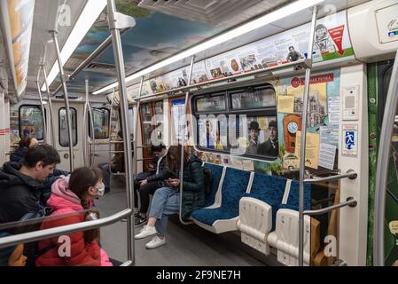 Sankt Petersburg, Russland – 15. April 2021: Menschen im U-Bahn-Zug mit Fotos aus den sowjetischen Filmen am Fenster. Stockfoto