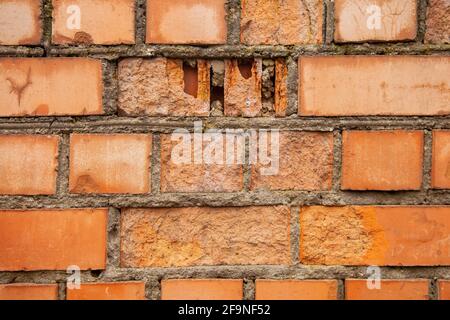 Alte Backsteinmauer aus roten Ziegeln. Eine Mauer niederreißen, die Ziegel zerfällt Stockfoto