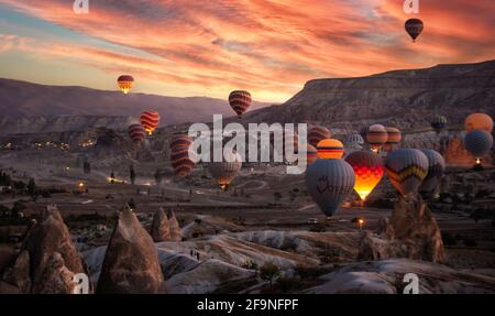 Goreme, Kappadokien, Türkei. Wunderschöne Szenen im Goreme Nationalpark. Hunderte von bunten Heißluftballons fliegen am Himmel bei Sonnenaufgang. Stockfoto