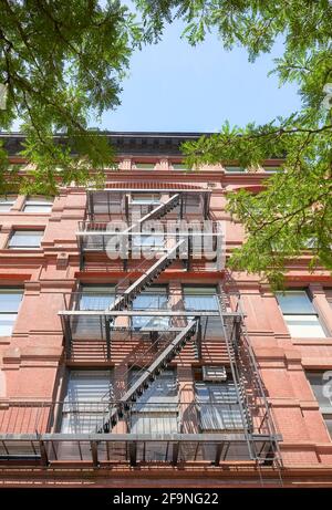 Blick auf ein altes rotes Backsteingebäude mit Feuerschutzanlage, New York City, USA. Stockfoto