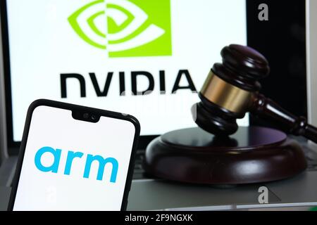 ARM-Firmenlogo auf dem Smartphone, gavel und NVIDIA-Logo auf dem unscharfen Apple M1 ARM-basierten Laptop-Bildschirm. Konzept für Firmenakquisition und eine Stockfoto