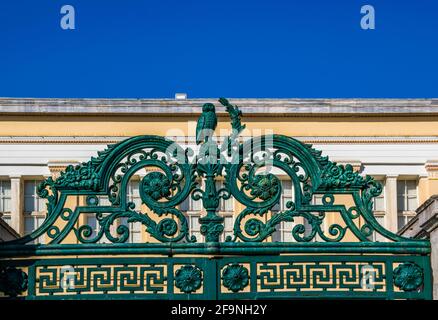 Eisenzaun mit Ornamenten, darunter eine Eule um die Uilding Der National & Kapodistrian University of Athens in Griechenland Stockfoto