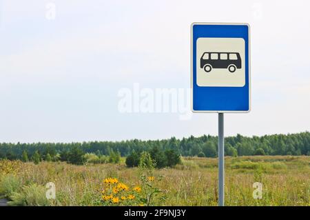 Straßenschild Öffentliche Verkehrsmittel halten vor dem Hintergrund der Sommerlandschaft. Sommerwiese mit Blumen und Gras. Stockfoto
