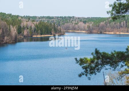 Grüner See in Vilnius, Litauen. Luftaufnahme des Sees umgeben von Wald und kleinem Boot mitten im Wasser im Frühling Stockfoto
