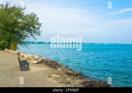 Blick auf eine Bank an einer Promenade entlang der Bodeensee See in der schweiz Stockfoto