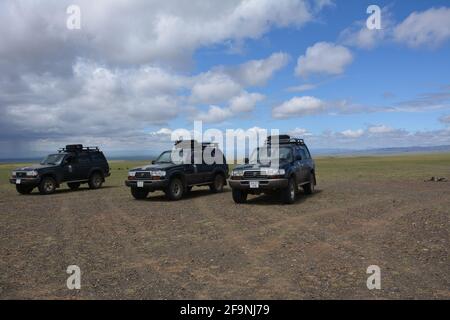 Touristische Geländewagen in der Nähe von Dungenee am / Canyon im Gobi Gurvan Saikhan National Park, Omnogovi, Mongolei. Stockfoto