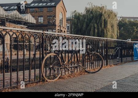 London, Großbritannien - 12. August 2020: Verrostetes Tandemrad, an einen Zaun gekettet, in Camden, London. Radfahren wurde zu einer beliebten Option für das Pendeln in der Hauptstadt. Stockfoto