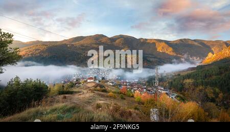 Devin, Bulgarien. Frühmorgendlicher Blick auf die kleine Stadt mit Nebel im Herbst. Umgeben von Bergen Stockfoto