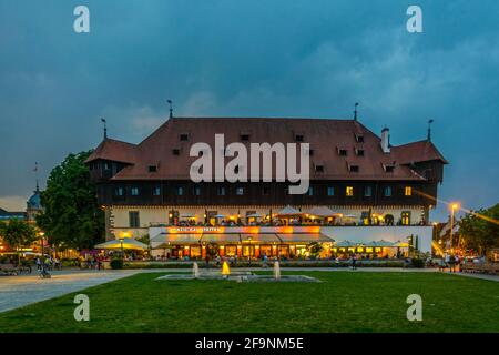 Nachtansicht des iiluminierten Gebäudes des Konstanzer Konzils in Deutschland. (schild sagt auf deutsch das Restaurant „Konzil“) Stockfoto