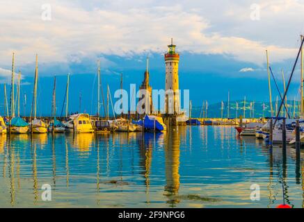 Blick auf eine Marina des Hafens von Lindau in Deutschland geschützt vom bodensee durch eine Löwenstatue und einen Leuchtturm. Stockfoto