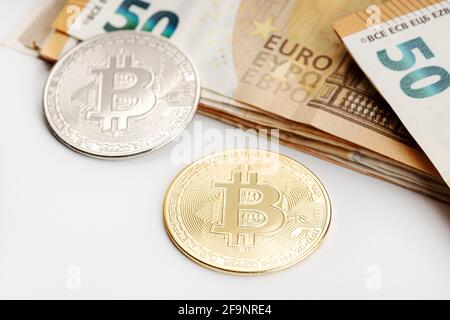 Bitcoin-Münzen und Euro-Banknoten. Kryptowährung im Vergleich zu fiat Money Concept Stockfoto