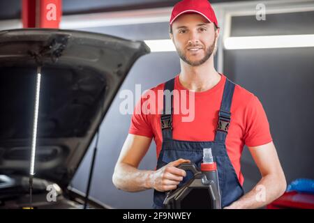 Mann in Overalls mit Kanister in den Händen Stockfoto