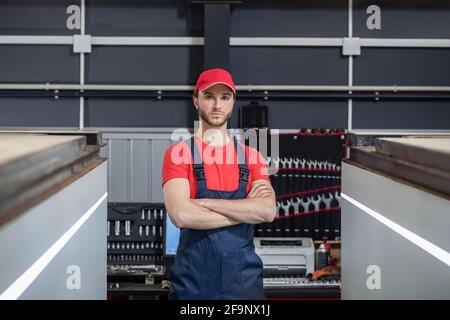 Mann in Arbeitskleidung, der in der Werkstatt steht Stockfoto