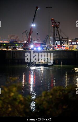 Hamburg, Deutschland. April 2021. Das geleerte Schnellboot (links) wird mit einem Feuerwehrkran zum Heben vorbereitet. Ein Schnellboot der Hamburger Polizei SEK musste aus dem Hafen in Steinwerder gerettet werden. Nach Angaben der Polizei hatten die Beamten am Montagabend einen Wasseransturm im Boot bemerkt, der an einem Anlegesteg der Wasserpolizei befestigt war. Quelle: Jonas Walzberg/dpa/Alamy Live News Stockfoto