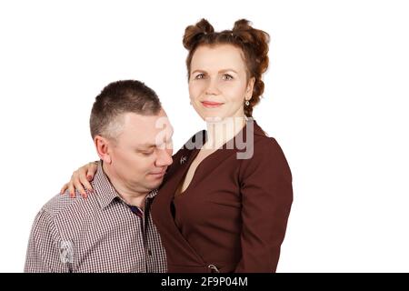 Porträt eines Ehepaares im Studio auf weißem Hintergrund. Mann, der auf die Brust seiner Frau schaut Stockfoto