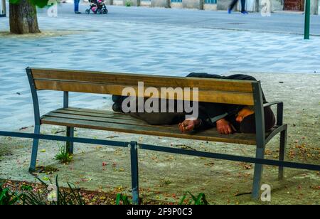 Obdachlose schlafen auf einer Bank im Zentrum von wien, österreich. Stockfoto