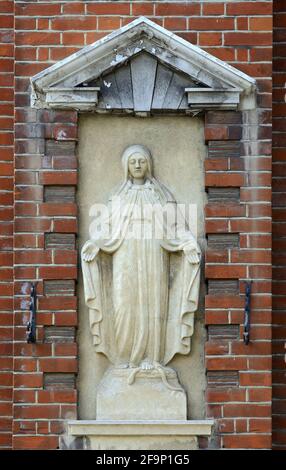 Canterbury, Kent, Großbritannien. Geschnitztes Relief der Virgin Mary, das auf einem skane an der Wand in der Nähe der römisch-katholischen St. Thomas-Kirche steht Stockfoto