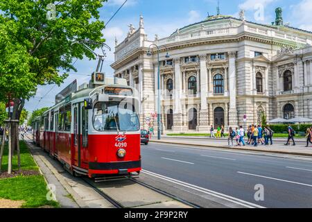Berühmte Wiener Ringstraße mit historischem Burgtheater (Kaiserliches Hoftheater) Und traditionelle rote elektrische Straßenbahn Stockfoto