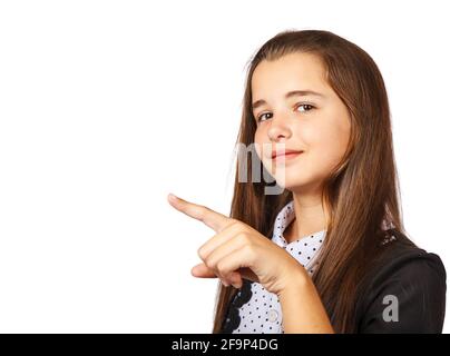 Positive schöne Brünette teen Mädchen mit langen Haaren zur Seite zeigend. Präsentieren Sie Ihr Produkt. Isoliert auf weißem Hintergrund Stockfoto