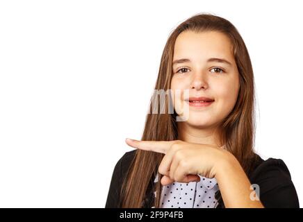 Positive schöne Brünette teen Mädchen mit langen Haaren zur Seite zeigend. Präsentieren Sie Ihr Produkt. Isoliert auf weißem Hintergrund Stockfoto