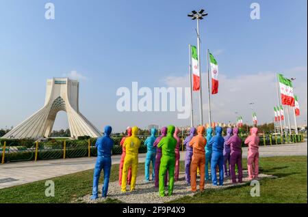 Eine Gruppe von gemalten Kopien eines Mannes, der den Azadi-Turm in Teheran, Iran, betrachtet. Stockfoto