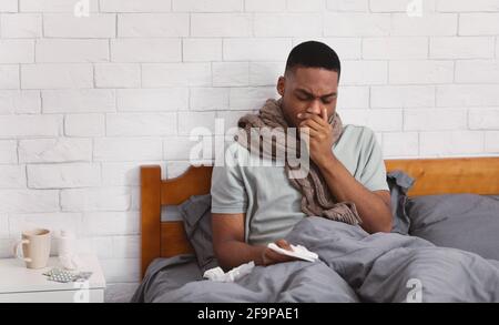 Krank Schwarz Mann Husten Leiden Lungenentzündung Sitzen Im Bett Im Innen Stockfoto