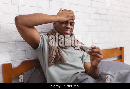 Ill Schwarz Kerl Mit Fieber Sitzen Im Bett Innen Stockfoto