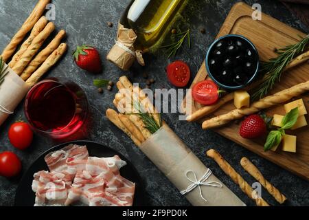 Grissini-Sticks, Snacks und Wein auf schwarzem rauchigen Hintergrund Stockfoto