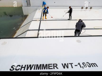 15. April 2021, Sachsen-Anhalt, Halle (Saale): Mitarbeiter der Bäder Halle GmbH reinigen das große Schwimmbad im Nordbad. Die Freibäder in Sachsen-Anhalt bereiten sich trotz der unsicheren Corona-Situation auf die kommende Saison vor. Mehrere Pools planen die Eröffnung ab dem 15. Mai unter Berücksichtigung möglicher pandemischer Veränderungen. Foto: Jan Woitas/dpa-Zentralbild/ZB Stockfoto