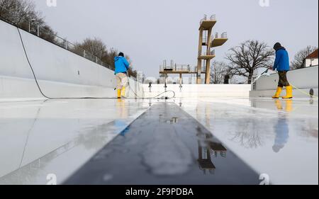 15. April 2021, Sachsen-Anhalt, Halle (Saale): Mitarbeiter der Bäder Halle GmbH reinigen das große Schwimmbad im Nordbad. Die Freibäder in Sachsen-Anhalt bereiten sich trotz der unsicheren Corona-Situation auf die kommende Saison vor. Mehrere Pools planen die Eröffnung ab dem 15. Mai unter Berücksichtigung möglicher pandemischer Veränderungen. Foto: Jan Woitas/dpa-Zentralbild/ZB Stockfoto